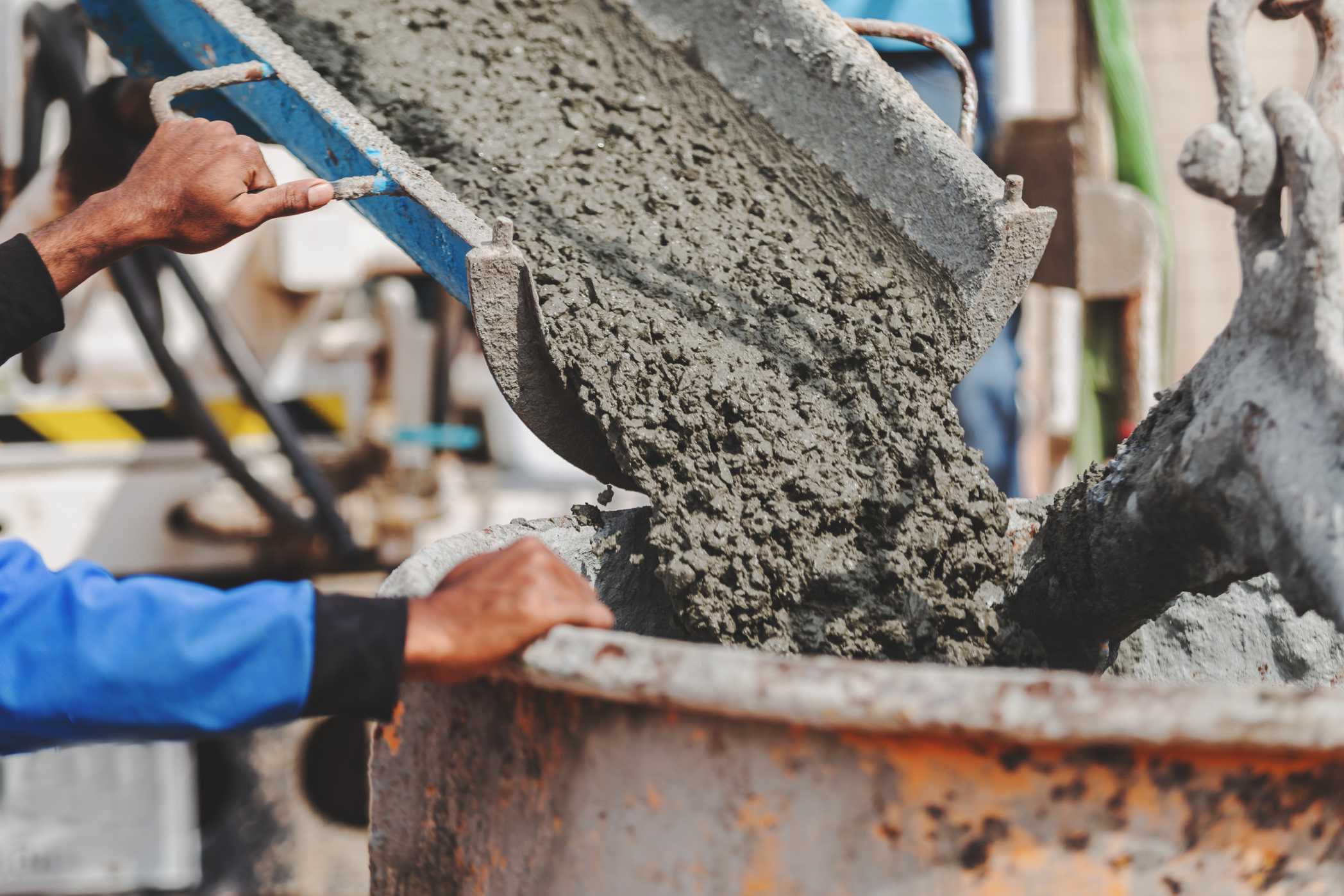 Wet concrete being poured from a chute into a container