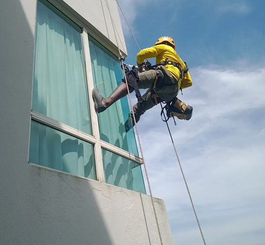 Suspended worker performing facade cleaning works on a building