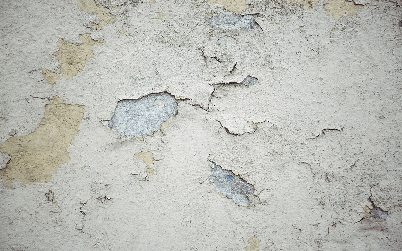Cracked-and-peeling-concrete-wall-damaged-by-climate-exposure
